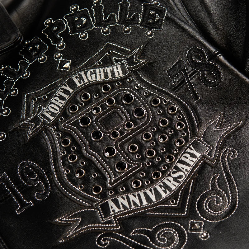 Detailed anniversary crest on the black Pelle Pelle jacket featuring a P emblem, 48 Years lettering, and decorative stud embellishments