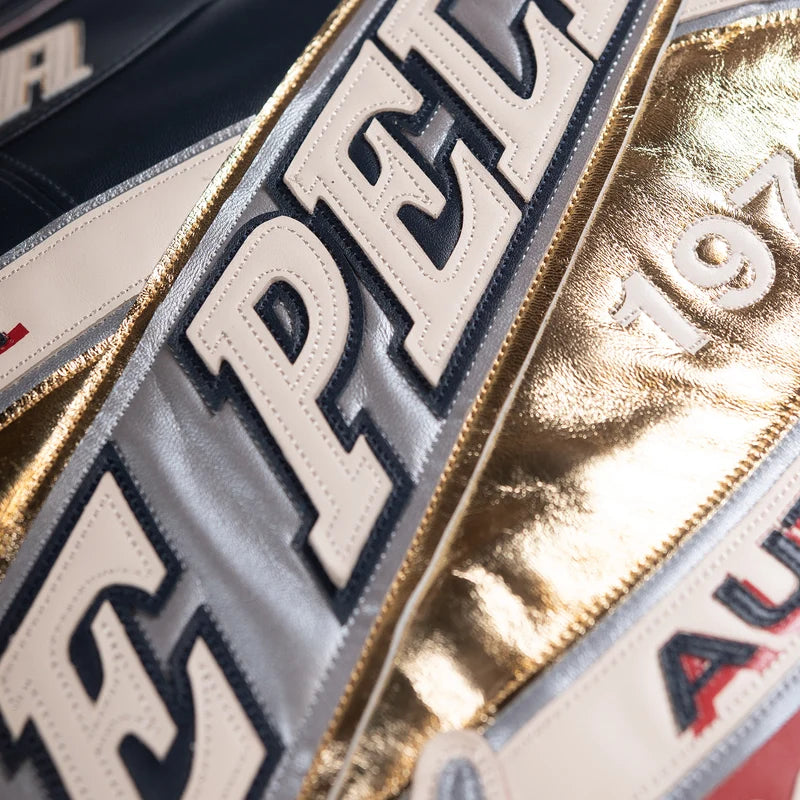 Close-up of Pelle Pelle USA jacket lettering with white appliqué, silver and metallic gold accents.