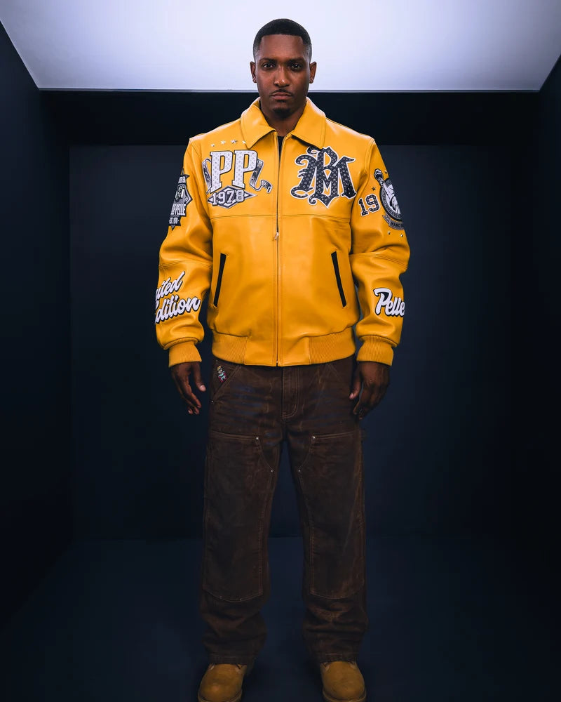 Model wearing a mustard yellow Pelle Pelle All Time Champions graphic jacket with dark trousers