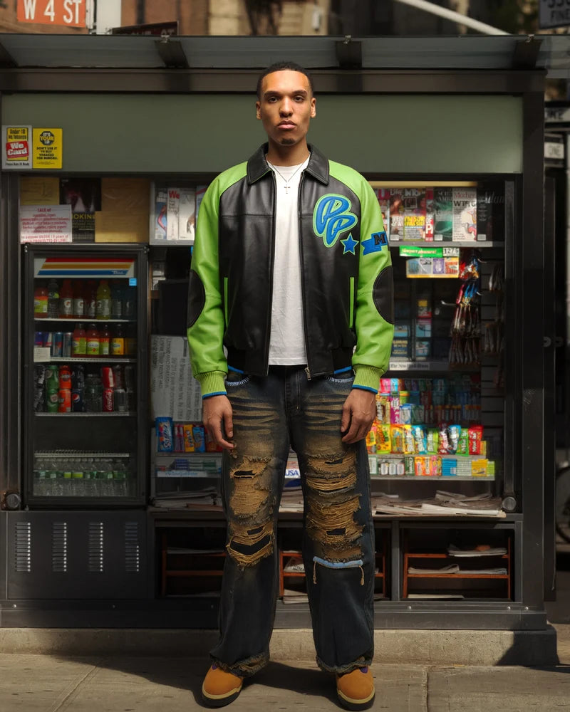 Model wearing a black Pelle Pelle Soda Club jacket with lime green sleeves, blue accents and graphic chest detail
