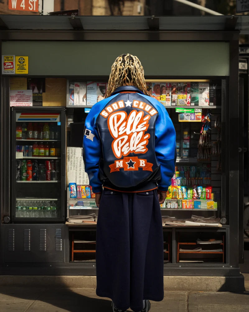 Model wearing the Pelle Pelle Classic Soda Club jacket with blue sleeves and bold back artwork.